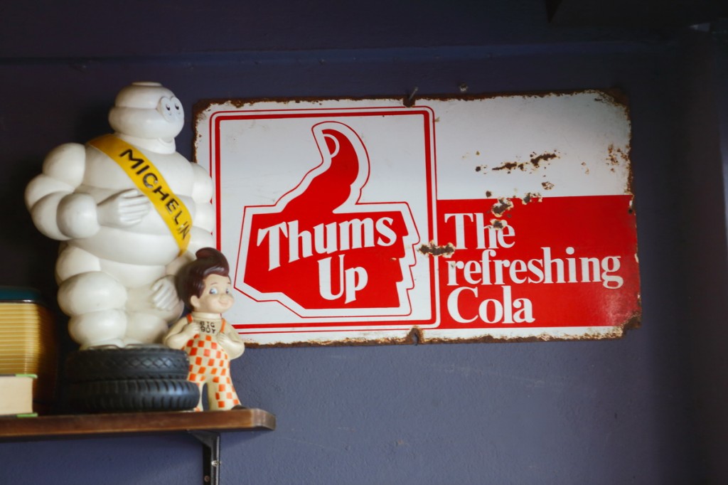 ตุ๊กตามัสคอตของ Michelin และ Big Boy ของสะสมในโรงจอดรถ ส่วนป้ายโลหะโฆษณาเครื่องดื่มเป็นของที่นำเข้ามาจากอเมริกา